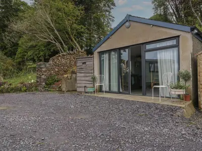 a small house with a patio and chairs in it at Penrallt Bach in Blaenau-Ffestiniog