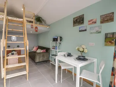 a living room with a desk and a bunk bed at Penrallt Bach in Blaenau-Ffestiniog