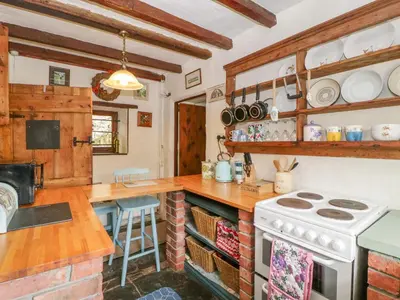 a kitchen with a stove and a counter top at Violet Cottage in Llangammarch Wells