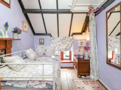 a bedroom with a bed and a desk at Violet Cottage in Llangammarch Wells