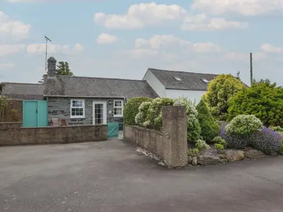 a house with a driveway in front of it at Ty Llaeth Cottage in Tywyn