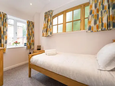 a bedroom with a bed and two windows at 2 bedroom home within walking distance of the town - Pass the Keys in Shrewsbury