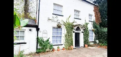 a white house with a door and ivy at St Julians house in Shrewsbury