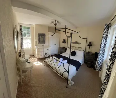 a bedroom with a black and white bed and a bathroom at St Julians house in Shrewsbury