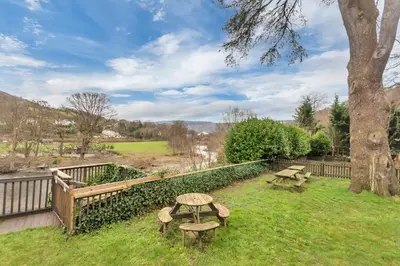 a park with two picnic tables and a tree at White Waters Bed and Breakfast in Llangollen