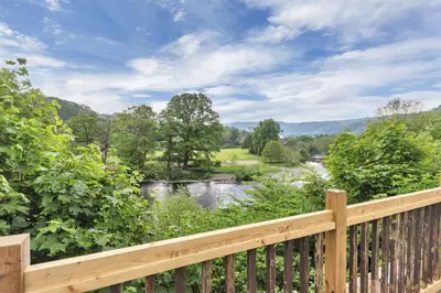 a view of a river from a wooden deck at White Waters Bed and Breakfast in Llangollen