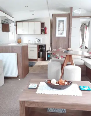a living room with a table with a bowl of food at Modern 2017 model Delta Sienna static caravan in Clarach Bay in Aberystwyth