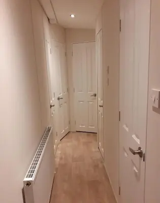 an empty hallway with white walls and wooden floors at Modern 2017 model Delta Sienna static caravan in Clarach Bay in Aberystwyth