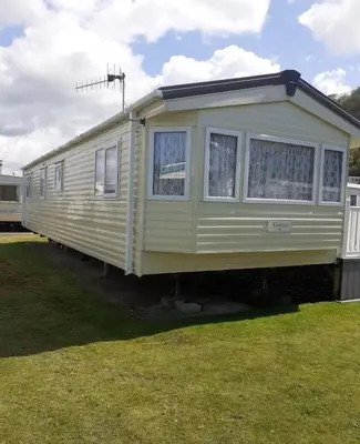 a yellow train car parked in the grass at Modern 2017 model Delta Sienna static caravan in Clarach Bay in Aberystwyth