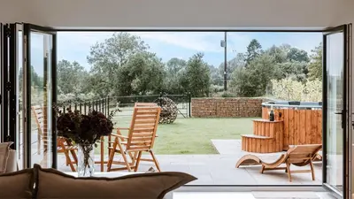 a living room with a large sliding glass door at The Old Dairy in Yarpole