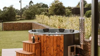 a jacuzzi tub sitting in a garden with a yard at The Old Dairy in Yarpole