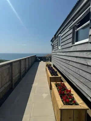 a row of flowers in wooden boxes on a balcony at Bay View shepherds hut with hot tub in Llanfair