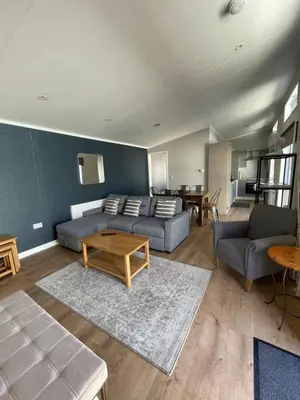 a living room with a couch and a table at Derw View Green Lodge in Aberystwyth
