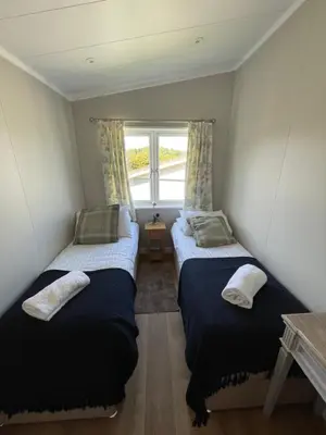two beds in a small room with a window at Derw View Green Lodge in Aberystwyth