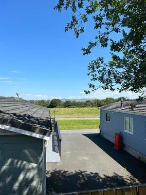 a garage and a house with a driveway at Derw View Green Lodge in Aberystwyth