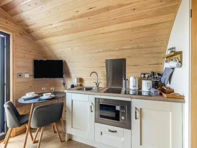 a kitchen with wooden walls and a table and chairs at Dyfi - Uk46064 in Llancynfelyn