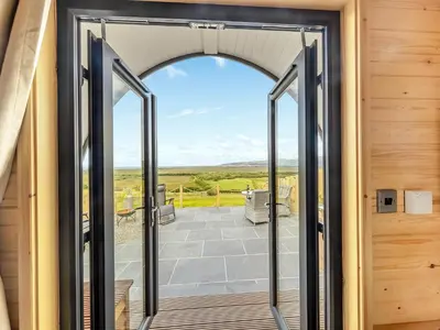 an open door to a patio with a view at Dyfi - Uk46064 in Llancynfelyn