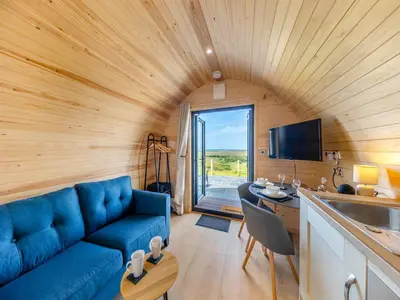 a living room with a blue couch in a room at Leri - Uk46065 in Llancynfelyn