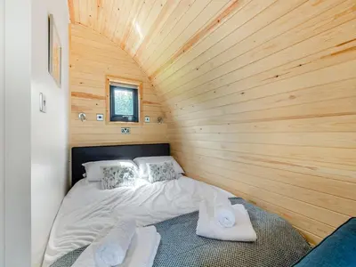 a bed in a room with a wooden wall at Leri - Uk46065 in Llancynfelyn