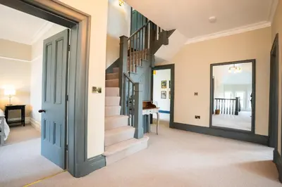 a staircase in a home with a blue door at Haulfryn in Barmouth