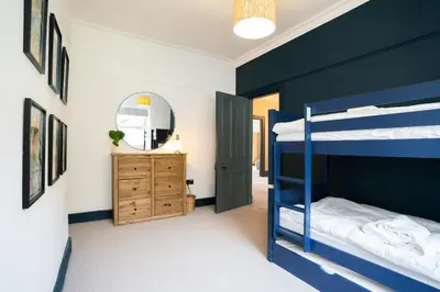 a bedroom with two bunk beds and a mirror at Haulfryn in Barmouth