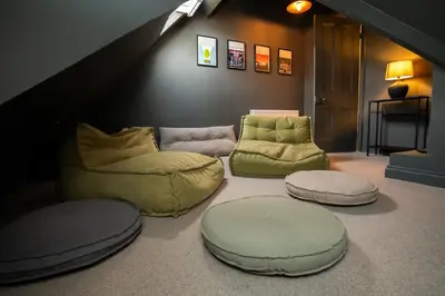 a living room with three ottomans and three chairs and a couch at Haulfryn in Barmouth