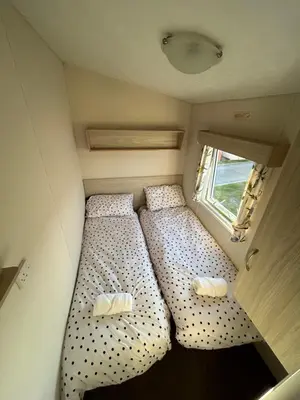 a small bedroom with two beds in a trailer at Caravan in Barmouth in Llanddwywe