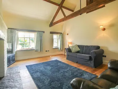 a living room with a couch and a chair at The Mytton at Mill Barn in Craven Arms