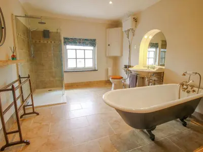 a bathroom with a tub and a shower and a sink at The Mytton at Mill Barn in Craven Arms