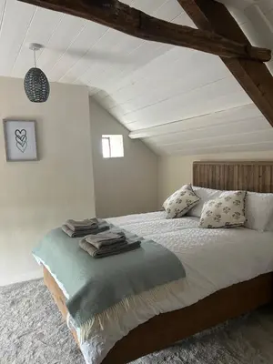 a bedroom with a large bed in a attic at Cosy countryside cottage in Aberystwyth