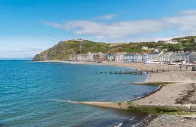 a view of a beach with buildings and the ocean at Lovley 3 bedroom Static Caravan in Clarach Bay in Aberystwyth