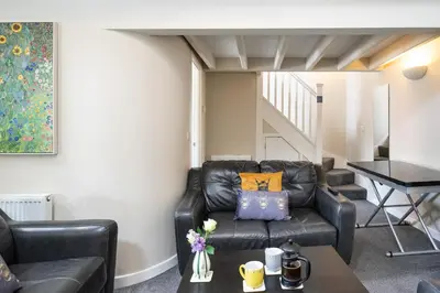 a living room with a leather couch and a table at Sunday School House in Shrewsbury
