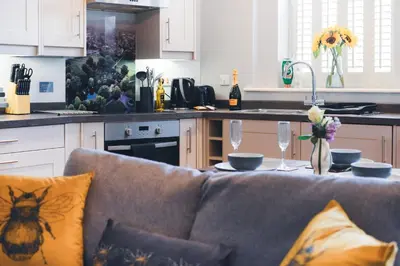 a kitchen with a couch and a table with wine glasses at The Little Cygnet in Shrewsbury