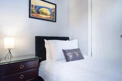a bedroom with a bed and a dresser with a lamp at The Little Cygnet in Shrewsbury