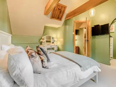 a bedroom with a white bed with a tv on the wall at Private Lodge with Spa and Sauna in Shrewsbury