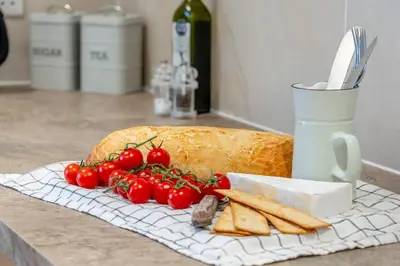 a counter with a loaf of bread and tomatoes and cheese at 1 Bed in Hay-on-Wye oc-c29788 in Hay-on-Wye