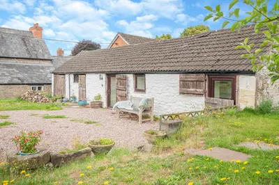 a white house with a bench in the yard at 1 Bed in Hay-on-Wye oc-c29788 in Hay-on-Wye