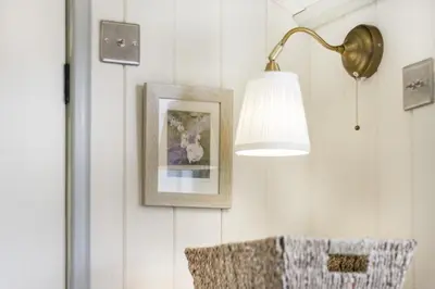 a lamp and a picture on a wall with a chair at 1 Bed in Leintwardine oc-b29785 in Brampton Bryan