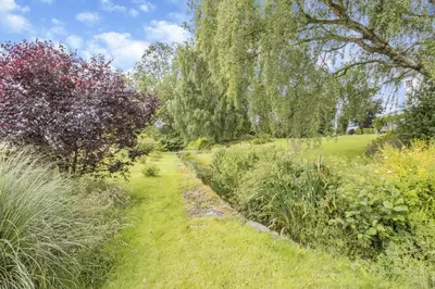 a path through a field with trees and grass at 1 Bed in Leintwardine oc-b29785 in Brampton Bryan