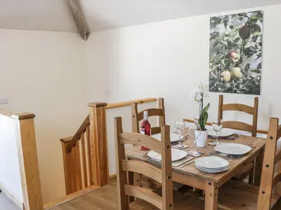 a dining room with a wooden table and chairs at Orchard Cottage in Newtown