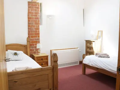 a bedroom with two beds and a dresser at Woodside Cottage in Newtown