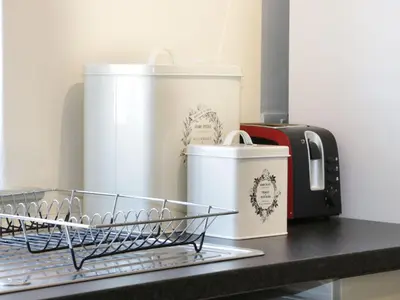 a dish drying rack on a counter with cups and a toaster at Ramblers in Newtown