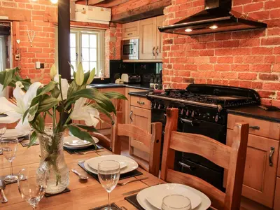 a kitchen with a table with plates and glasses on it at Garden Cottage in Newtown