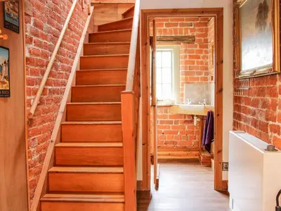 a brick hallway with stairs and a sink at Garden Cottage in Newtown