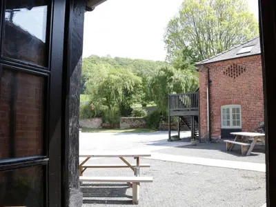 a view of a patio with a bench and a building at Garden Cottage in Newtown