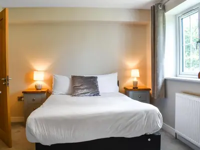a bedroom with a large bed with two lamps at Haul Y Bore in Aberystwyth
