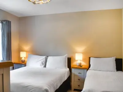 two beds in a room with two lamps at Haul Y Bore in Aberystwyth