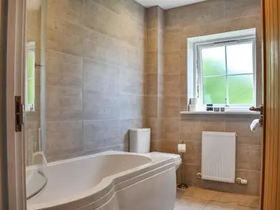 a bathroom with a large tub and a window at Haul Y Bore in Aberystwyth