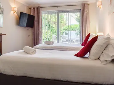 two beds in a room with a window at Tan Y Gaer in Aberystwyth