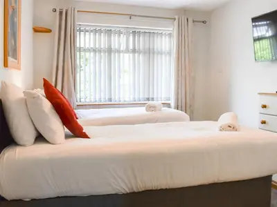 two beds in a bedroom with a window at Tan Y Gaer in Aberystwyth